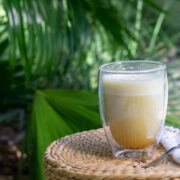 Turmeric golden milk in front of lush green background