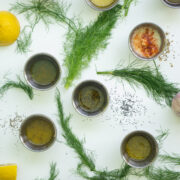 nine salad dressings garnished with fennel and lemon