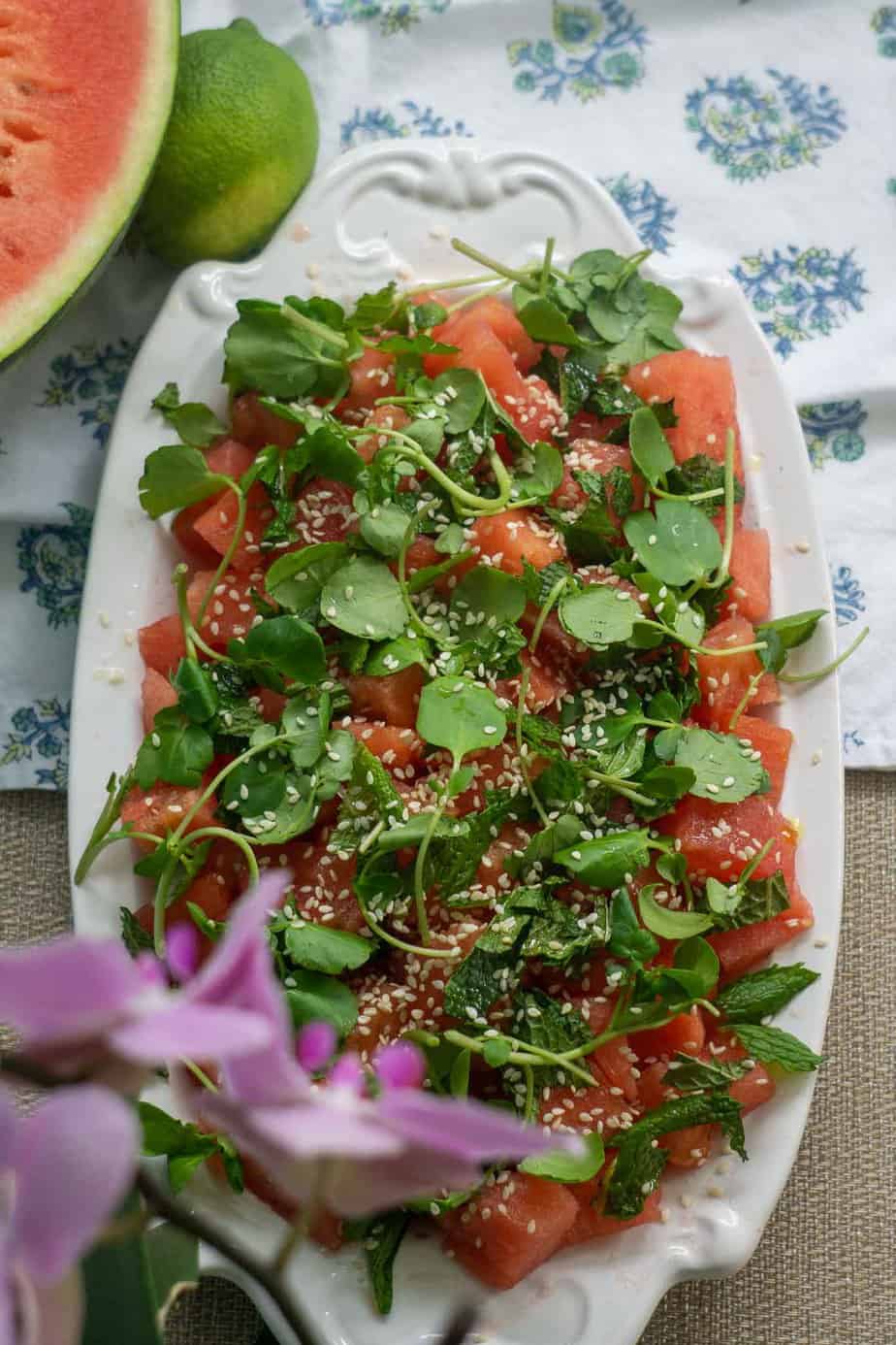 watermelon salad on blue table cloth with watermelon slice and lime