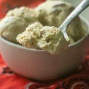 a heaping spoonful of butter pecan ice cream in front of a bowl
