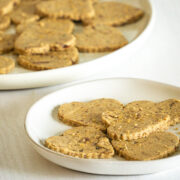 peanut butter cookies on a white plate in the foreground and in the background