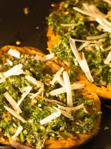 baked sweet potatoes topped with pesto and cheese
